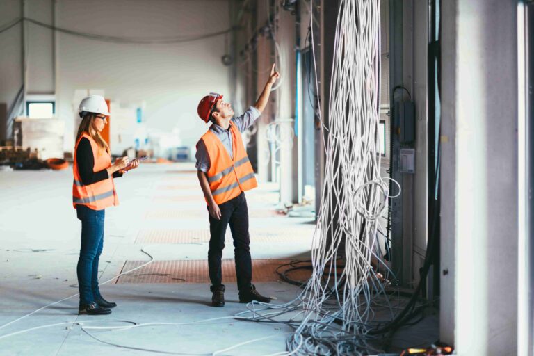 pessoas em obra olhando fios elétricos vindo do teto